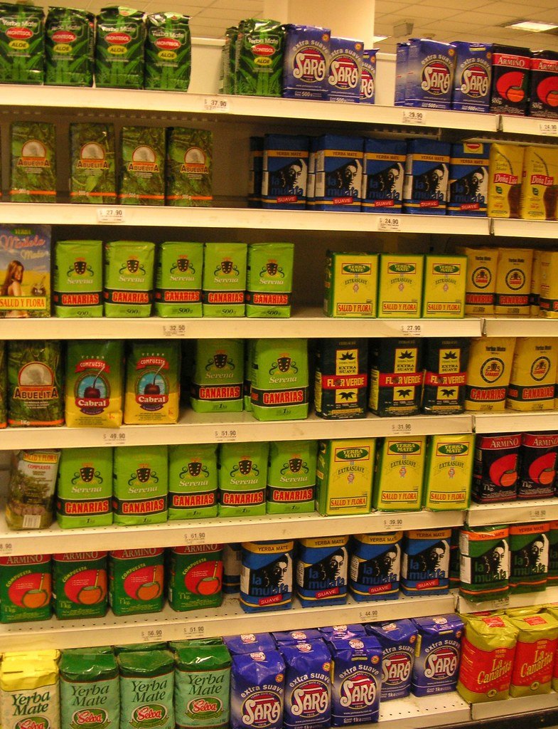 Góndola de almacén con productos de yerba mate y precios