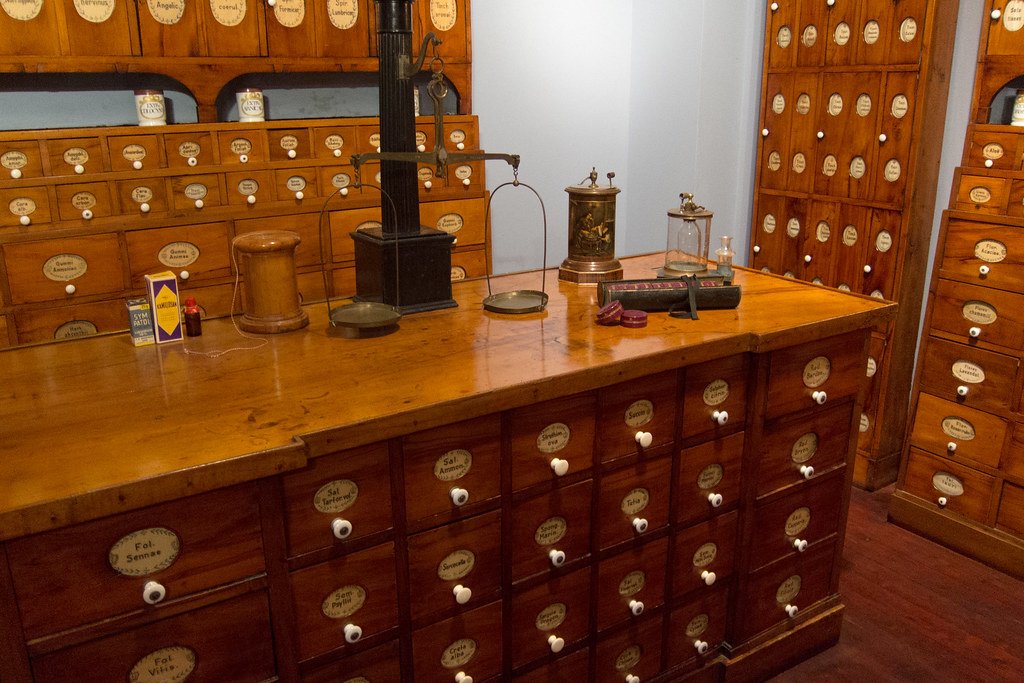 Mostrador de una farmacia de barrio con estanterías de madera